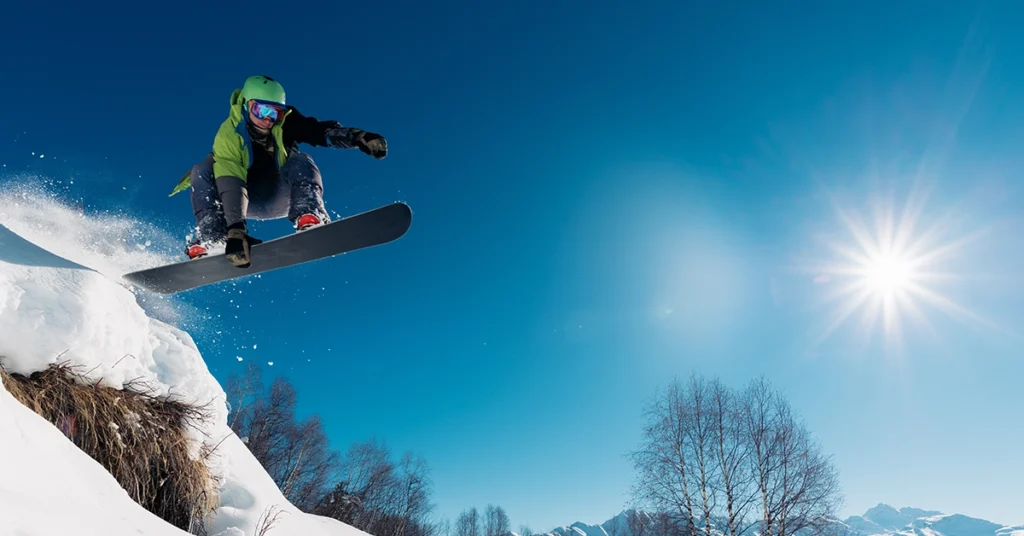 A snowboarder grabs his board and gets airborne